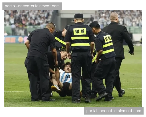 特写：小球迷冲入场内与偶像合影，被安保人员迅速带离